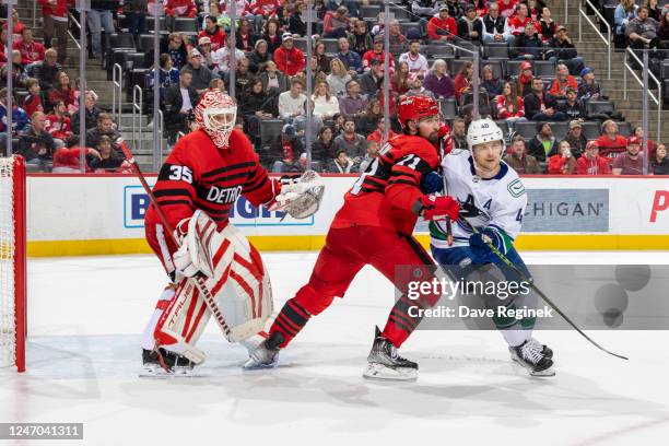 Ville Husso of the Detroit Red Wings follows the play as Dylan Larkin defends against Elias Pettersson of the Vancouver Canucks during the second...