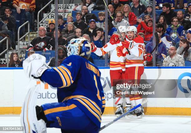 Dennis Gilbert of the Calgary Flames celebrates his second period goal against Ukko-Pekka Luukkonen of the Buffalo Sabres with Elias Lindholm during...