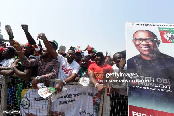 Supporters chant party slogans next to a banner of the candidate of the Labour Party Peter Obi during a campaign rally of the party in Lagos, on...