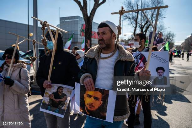 People protesting simulating being hanged during a demonstration against executions and human rights violations in Iran marching to the Iranian...