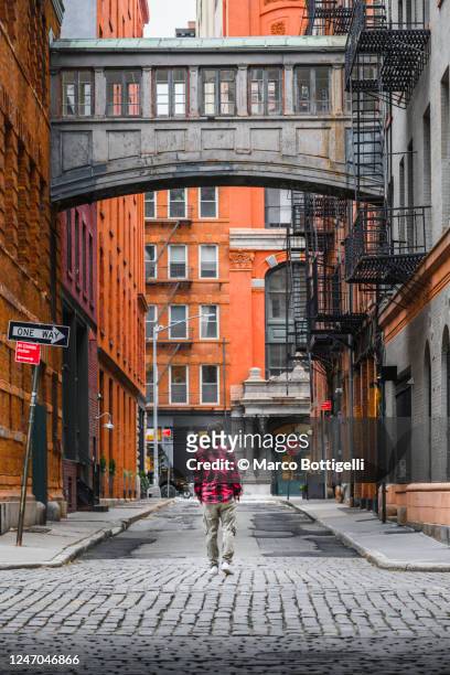 one man walking in tribeca, new york city - narrow stockfoto's en -beelden