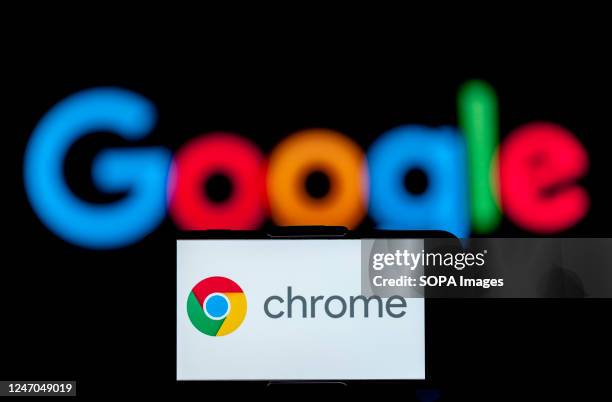 In this photo illustration, the logo of chrome is seen displayed on a mobile phone screen with a google logo in the background.