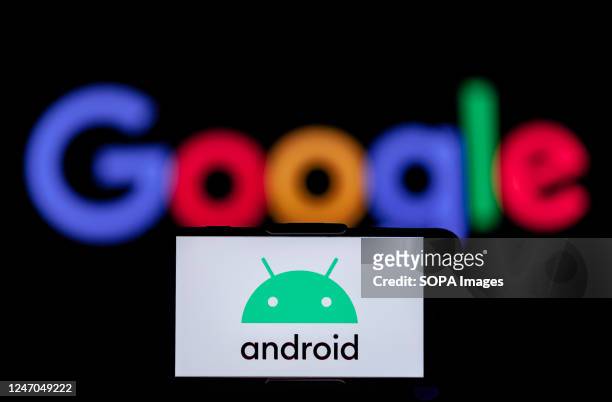 In this photo illustration, the logo of an android is seen displayed on a mobile phone screen with a google logo in the background.