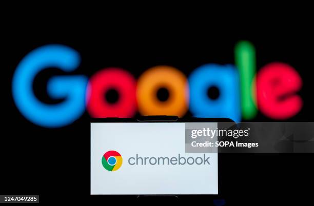 In this photo illustration, the logo of chromebook is seen displayed on a mobile phone screen with a google logo in the background.