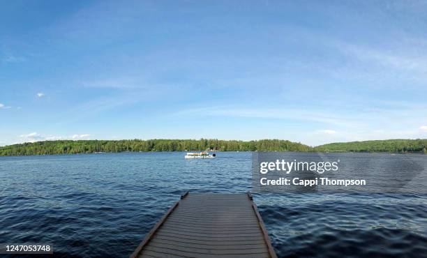 pontoon boat crossing pennesseewassee lake in norway, maine usa during summer - floating platform stock pictures, royalty-free photos & images