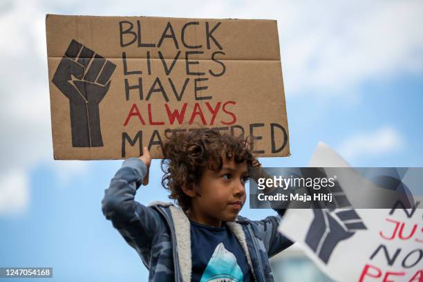 Boy holds a sign "Black lives have always mattered" during protest against racism and police brutality on June 06, 2020 in Alexanderplatz in Berlin,...