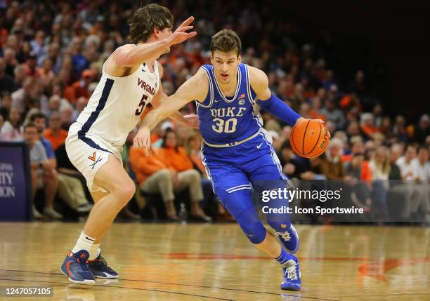 Duke Blue Devils center Kyle Filipowski dribbles the ball while attempting to elude Virginia Cavaliers forward Ben Vander Plas during a men's college...