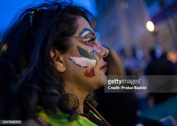 Protester painted a pigeon sign with Iranian flag colors on her cheek as she attended a demonstration to denounce the Iranian government and express...