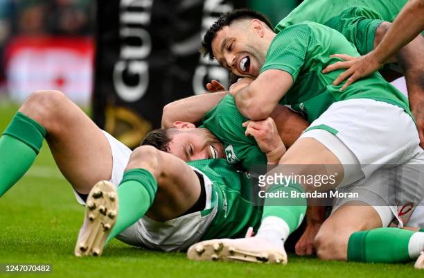Dublin , Ireland - 11 February 2023; Hugo Keenan of Ireland, centre, is congratulated by teammates Jonathan Sexton and Conor Murray after scoring...