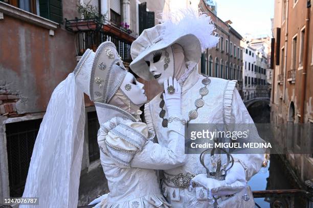 Masked revellers wearing a period costume pose during the carnival in Venice on February 12, 2023.