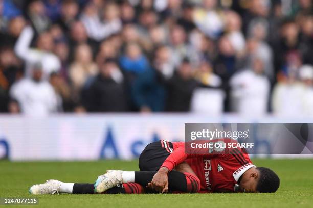 Manchester United's English striker Marcus Rashford lies injured during the English Premier League football match between Leeds United and Manchester...