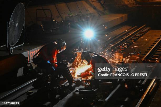 Workers weld rails in the Channel Tunnel during a "sleepless night" reserved for maintenance, on February 12, 2023. - The Channel Tunnel opened in...