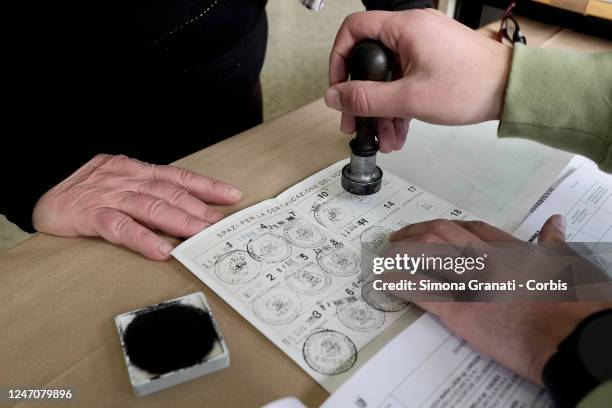 Teller stamps a voter's electoral card in a polling station for the renewal of the office of President of the Region and of the Regional Council in...