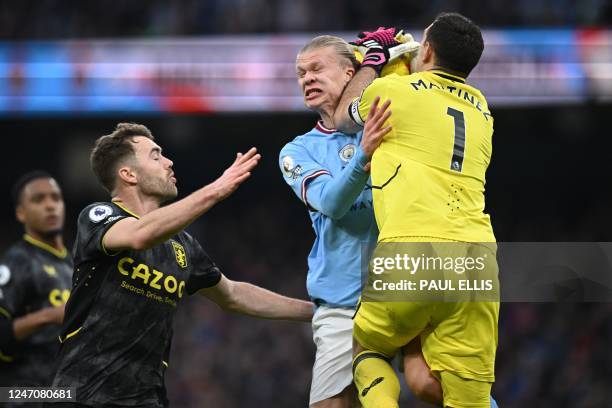 Aston Villa's Argentinian goalkeeper Emiliano Martinez and Manchester City's Norwegian striker Erling Haaland collide during the English Premier...