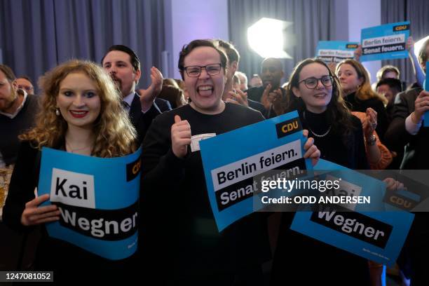 Party members of the Christian Democratic Union party react after the first exit poll results for the state's repeat elections at the State...