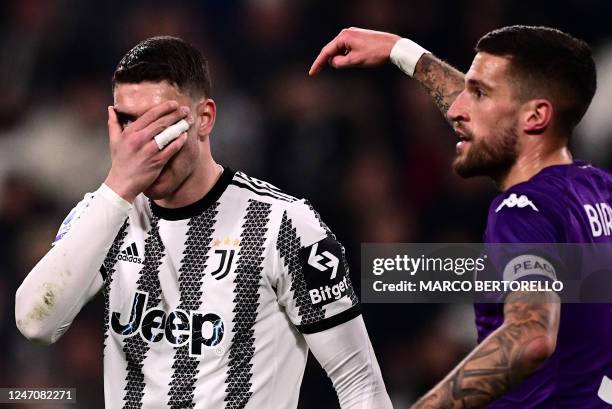 Juventus' Serbian forward Dusan Vlahovic and Fiorentina's Italian defender Cristiano Biraghi react during the Italian Serie A football match between...