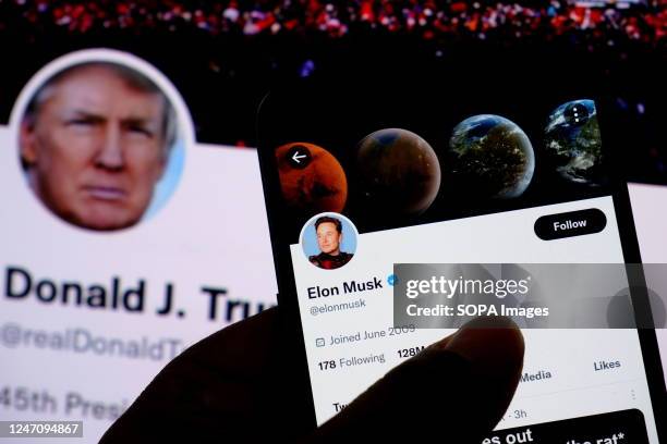 In this photo illustration, Elon Musk's twitter account is seen displayed on a smartphone with Donald Trump's Twitter account in background.