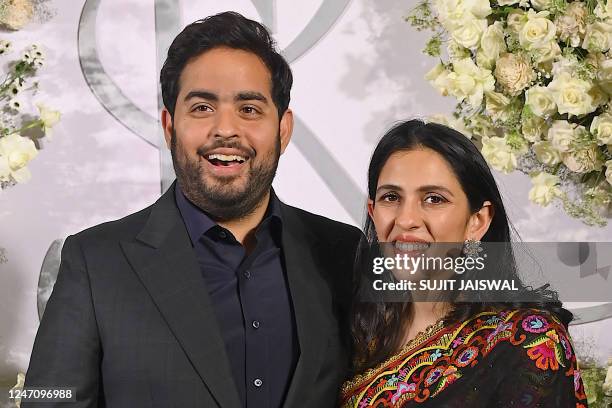In this photograph taken on February 12 Indian businessman Akash Ambani and his wife Shloka Mehta pose during the wedding reception party of...