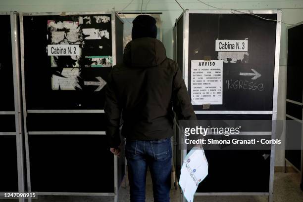 Young man enters a voting booth before casting his vote in a polling station for the renewal of the office of President of the Region and of the...