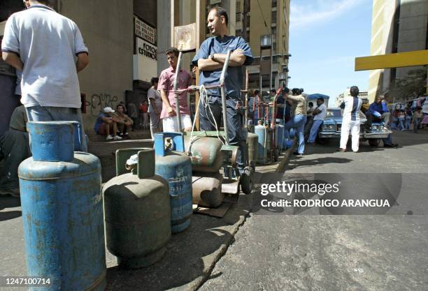 Group of people wait with their gas tanks for the distribution truk. Oil-rich Venezuela again ran out of gasoline 10 January, further stoking tension...