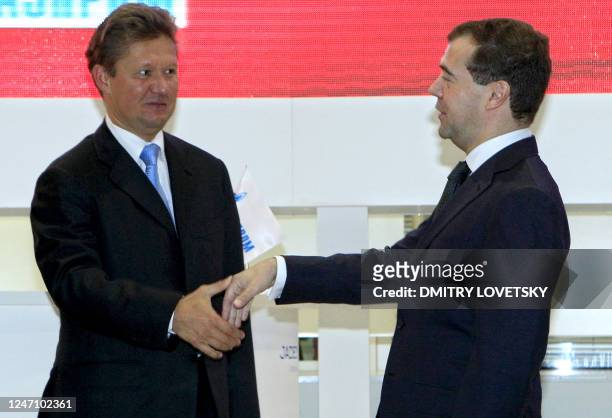 Russia's state-controlled gas company Gazprom CEO Alexei Miller, left, shakes hands with Russian President Dmitry Medvedev, right, after signing an...