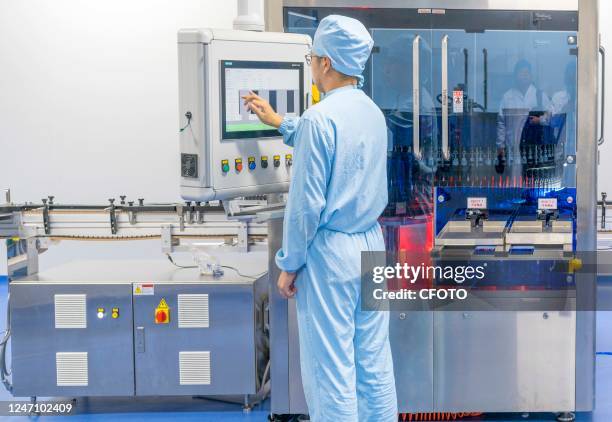 Technicians perform lamp inspection on COVID-19 vaccine ReCOV products at the Reco Biological workshop in Taizhou, Jiangsu province, China, December...