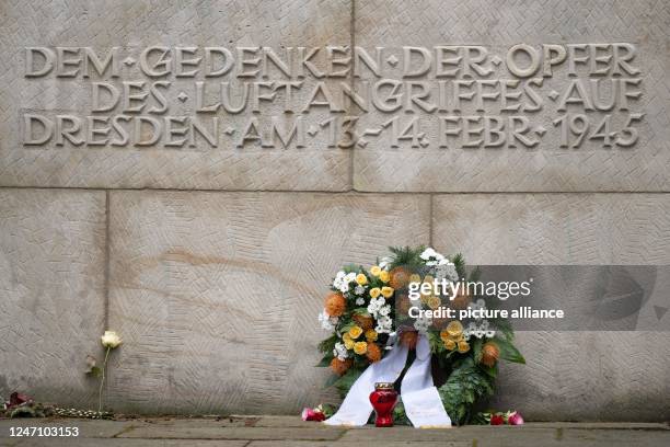 February 2023, Saxony, Dresden: A wreath of flowers lies in Heidefriedhof cemetery in front of the memorial stone for the victims of the bombing raid...