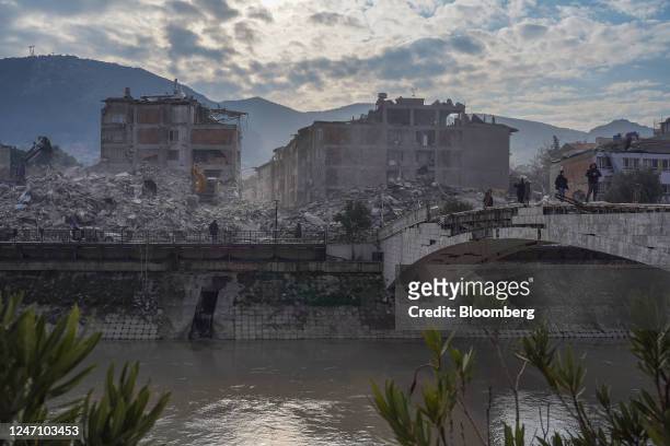Badly-damaged bridge spans the Orontes River in view of collapsed residential buildings in Hatay, Turkey, on Saturday, Feb. 11, 2023. The two massive...