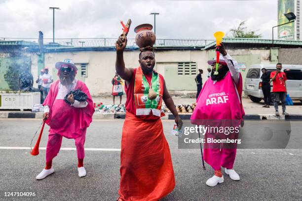 Supporter wearing a calabash bowl on his head dances and chants slogans during a campaign rally for Peter Obi, presidential candidate for the Labour...