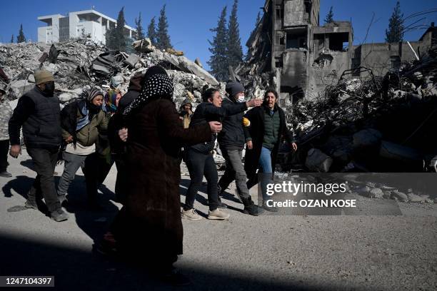 Relatives react after identifying a body as a family member in Kahramanmaras, southern Turkey on February 13 after a 7.8 magnitude earthquake struck...