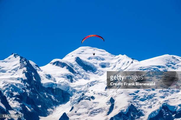 Paraglider flies against the backdrop of the Mont Blanc summit.