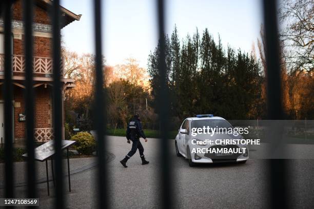 Municipal policeman walks next to a car of city of Paris' security services in the Buttes-Chaumont park, in the 19th arrondissement of Paris, on...