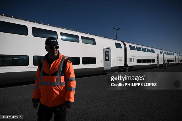 An Alstom employee walks by the new SNCF TGV "M" next generation high-speed train at the Alstom plant in La Rochelle, western France, on February 13,...