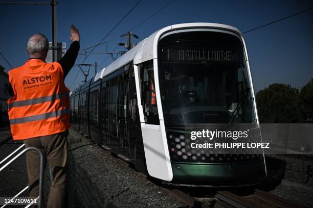 An Alstom employee waves to the tramway Citadis XO5 during a demonstration ride at the Alstom plant in La Rochelle, western France, on February 13,...