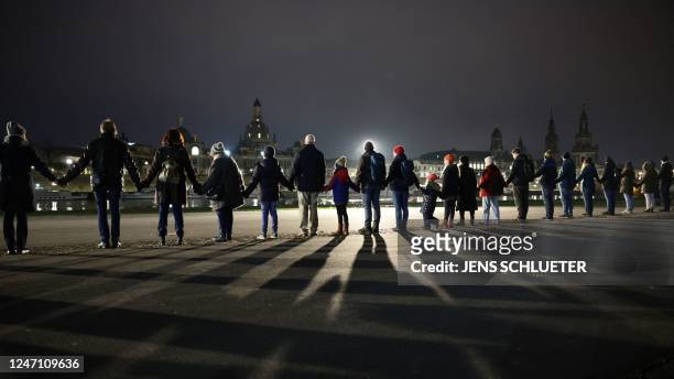 People hold hands to create a human chain along the banks of the River Elbe in Dresden, eastern Germany on February 13 during commemorations of the...