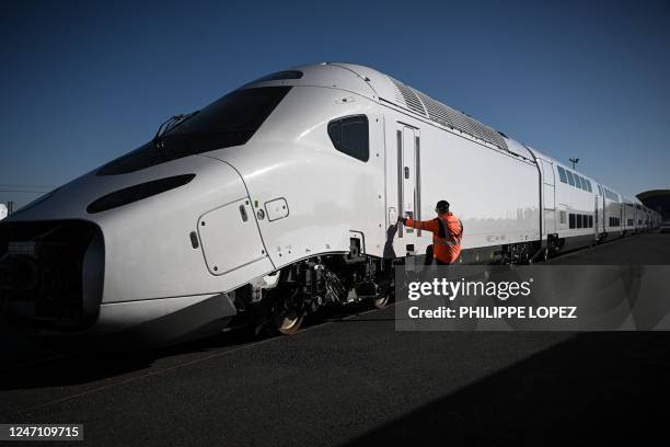 An Alstom employee checks the door of the new SNCF TGV "M" next generation high-speed train at the Alstom plant in La Rochelle, western France, on...