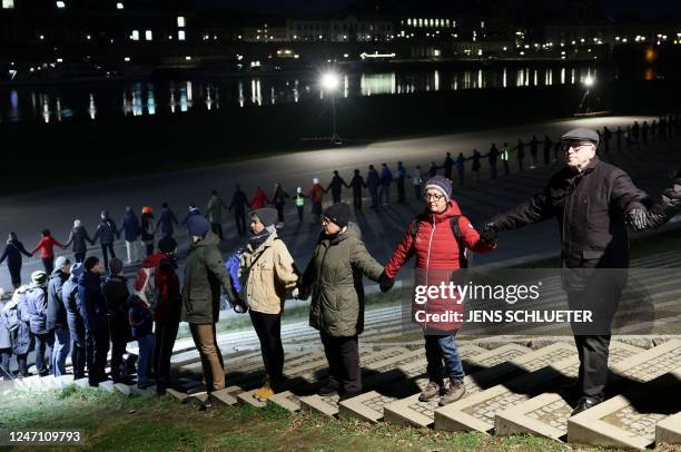 People hold hands to create a human chain along the banks of the River Elbe in Dresden, eastern Germany on February 13 during commemorations of the...