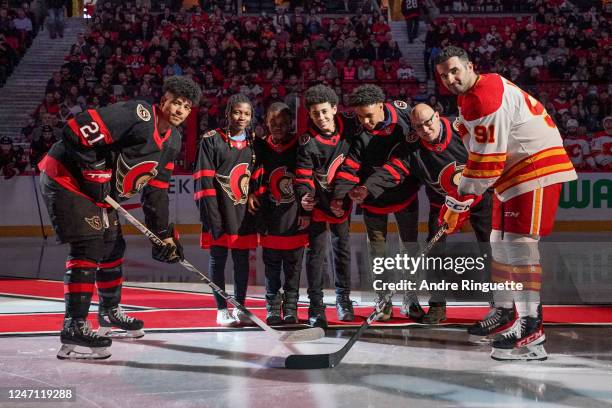 Mathieu Joseph of the Ottawa Senators and Nazem Kadri of the Calgary Flames take a ceremonial face-off with members of the African Hockey Association...