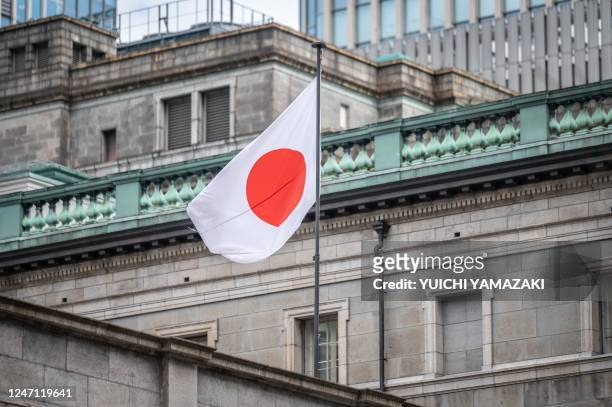 The Japanese national flag is seen at the Bank of Japan headquarters in Tokyo on February 14, 2023. - Economics professor Kazuo Ueda was nominated on...
