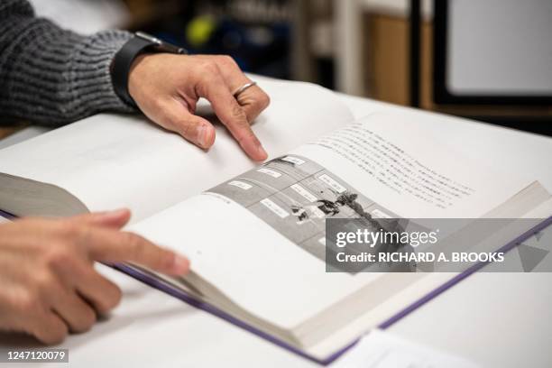 This photo taken on February 10, 2023 shows Masaaki Koido, an associate professor at Japan's University of Tsukuba, looking at the graduation thesis...