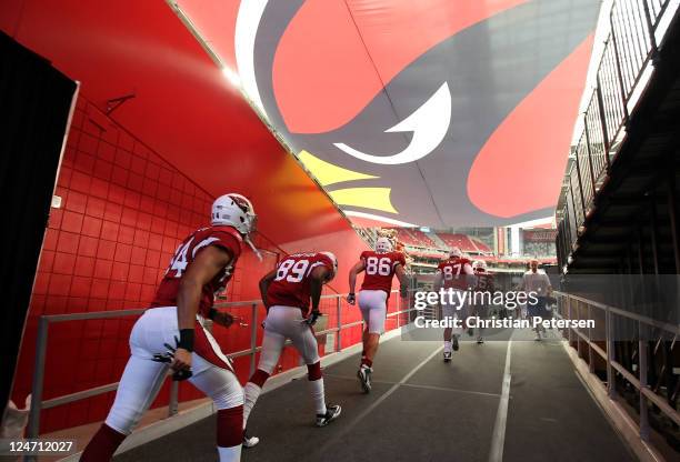 The Arizona Cardinals run out onto the field for warm ups to the NFL season opener game against the Carolina Panthers at the University of Phoenix...