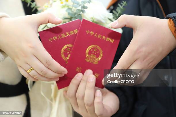 Couple shows their marriage certificate at the marriage registration office of Funing County Civil Affairs Bureau in Yancheng City, East China's...