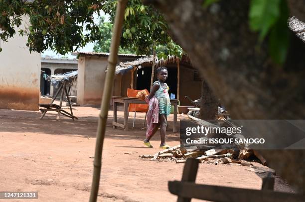 Child walks in the village of Kpo-Kahankro , near Bouake in Ivory Coast on February 9, 2023. - 21 people in the village of Kpokahankro have died in...