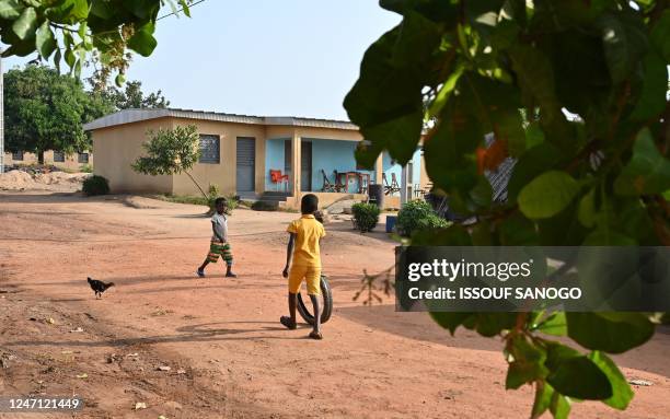 Children play in the street in the Kpo-Kahankro village, near Bouake, on February 10, 2023. - 21 people in the village of Kpokahankro have died in...