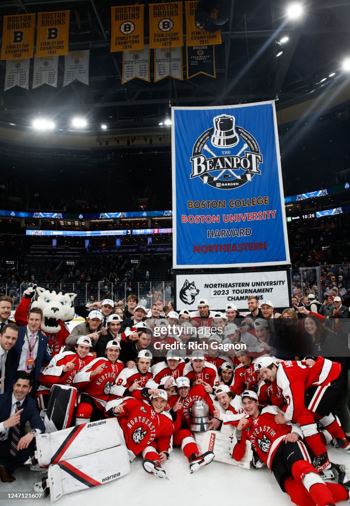 The Northeastern Huskies celebrate with the Beanpot trophy after a