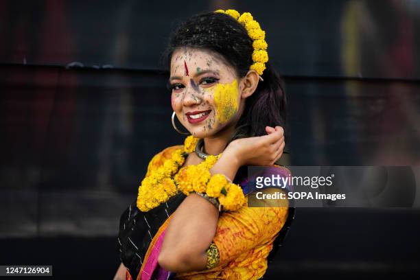 Woman wearing floral ornaments and the colours of Spring poses during Basanto Utsav the first day of spring in Dhaka. Pohela Falgun also known as the...