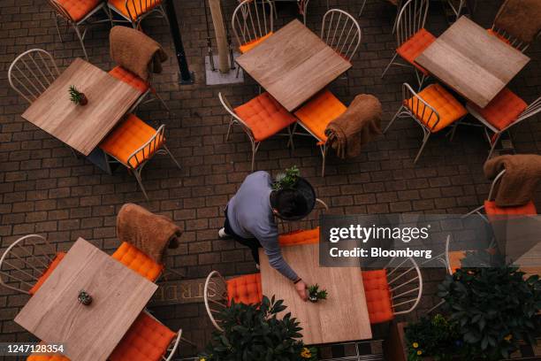 Waiter sets tables at a restaurant in Kingly Court in the Soho district in central London, UK, on Wednesday, Feb. 2, 2023. Now with an empire that...