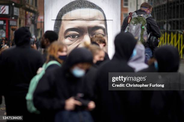 Protesters pay their respects by a street art portrait of George Floyd during a second day of Black Lives Matter demonstrations in Piccadilly Gardens...