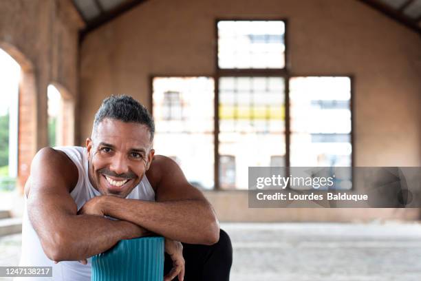 sport man in the street with yoga mat - yoga instructor stock pictures, royalty-free photos & images