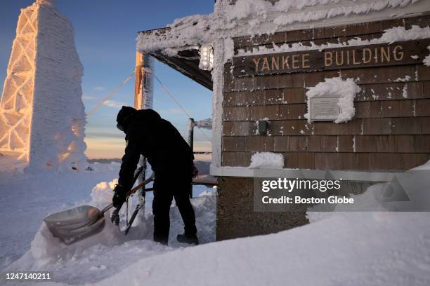 Mount Washington, NH Patrick Hummel, Park Manager for Mount Washington State Park, shovels out the steps that lead to the Yankee Building as the sun...